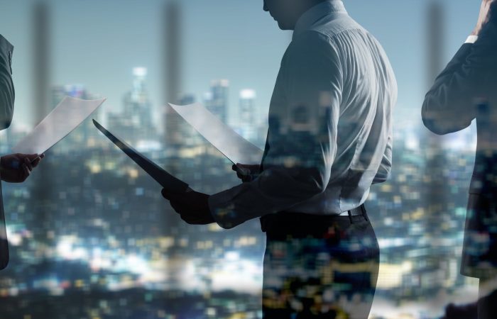 businessman with paper standing in night office